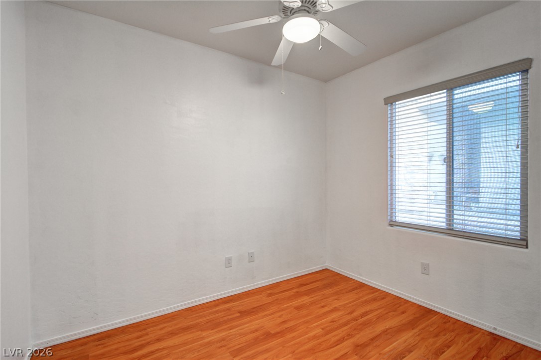 2339 Tranquil Moon Street Henderson, NV 89044 - Photo 10 of 15 Warm wood flooring pairs beautifully with clean, neutral walls in this versatile secondary bedroom.