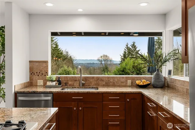 a kitchen with a sink a counter and a view of living room
