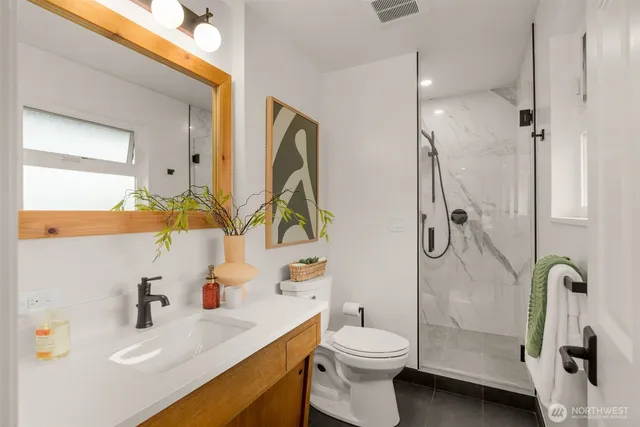 a bathroom with a sink a toilet and shower