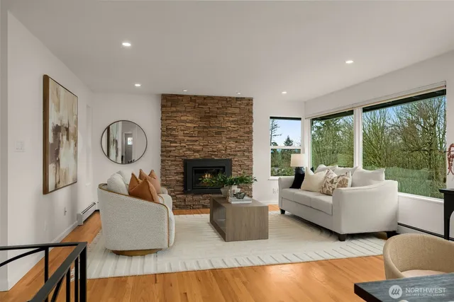 a living room with furniture a large window and a fireplace