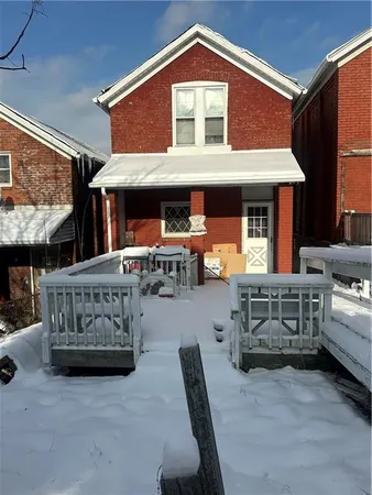 a front view of a house with barbeque and wooden fence