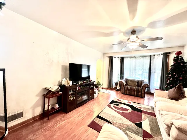 a living room with furniture and a flat screen tv with wooden floor