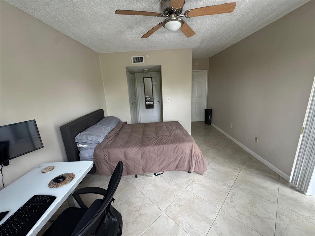 2600 South University Drive, Unit 309 Davie, FL 33328 - Photo 14 of 23 a bedroom with a bed and a chandelier