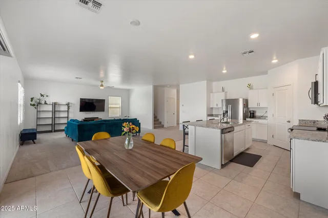 a living room with furniture kitchen view and a chandelier