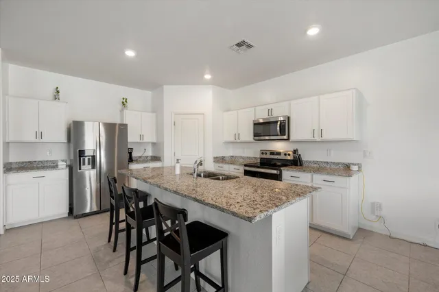 a kitchen with stainless steel appliances granite countertop a stove a sink and a microwave