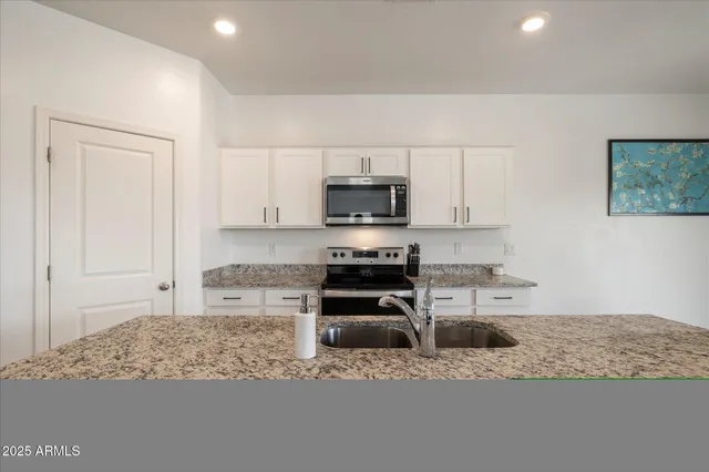 a kitchen with sink and living room