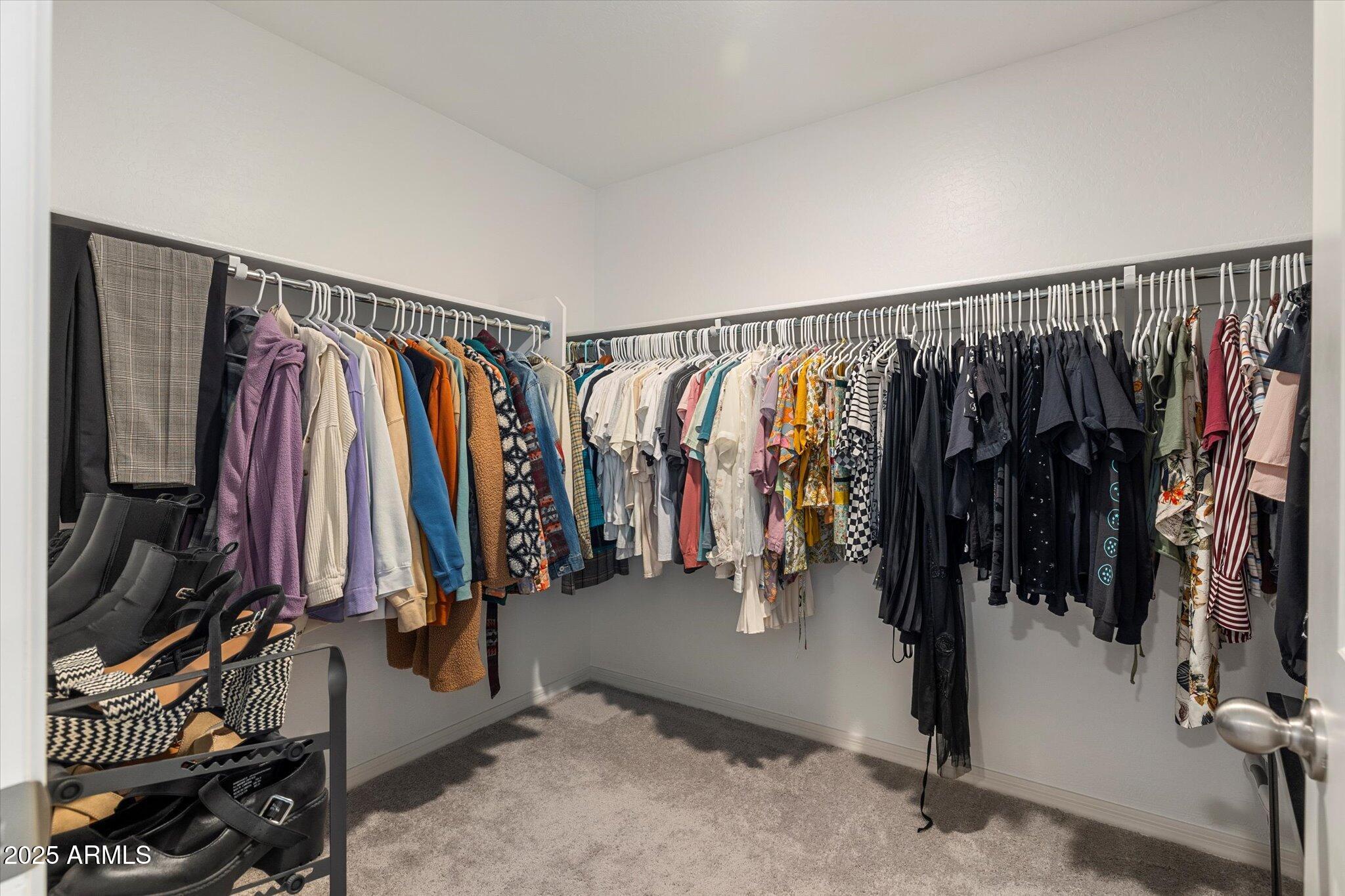 6350 West Latona Road Laveen, AZ 85339 - Photo 19 of 42 a view of walk in closet with clothes