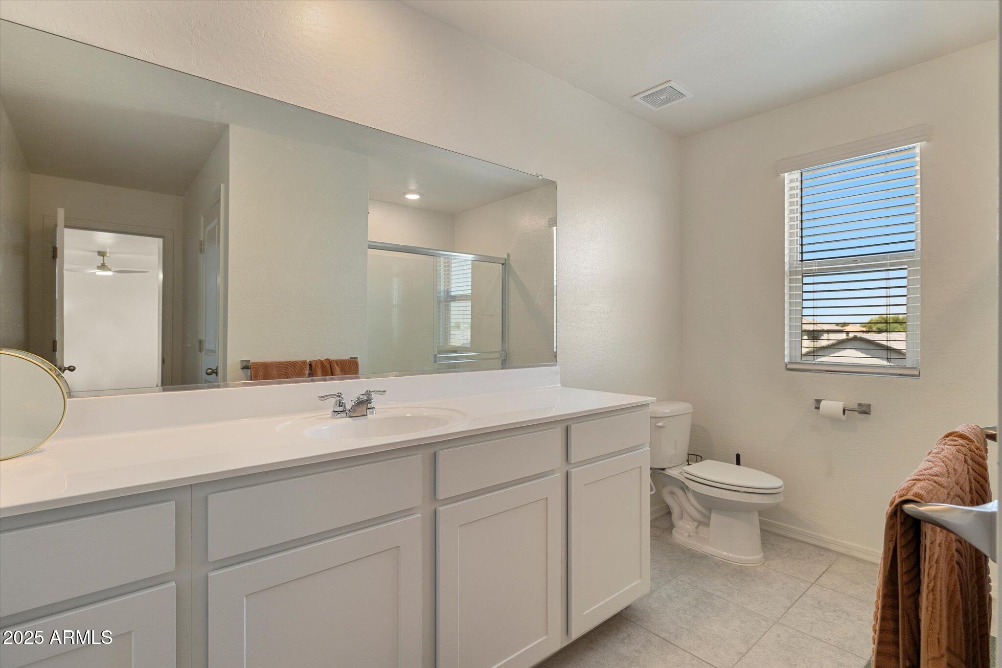 6350 West Latona Road Laveen, AZ 85339 - Photo 21 of 42 a bathroom with a toilet sink and mirror