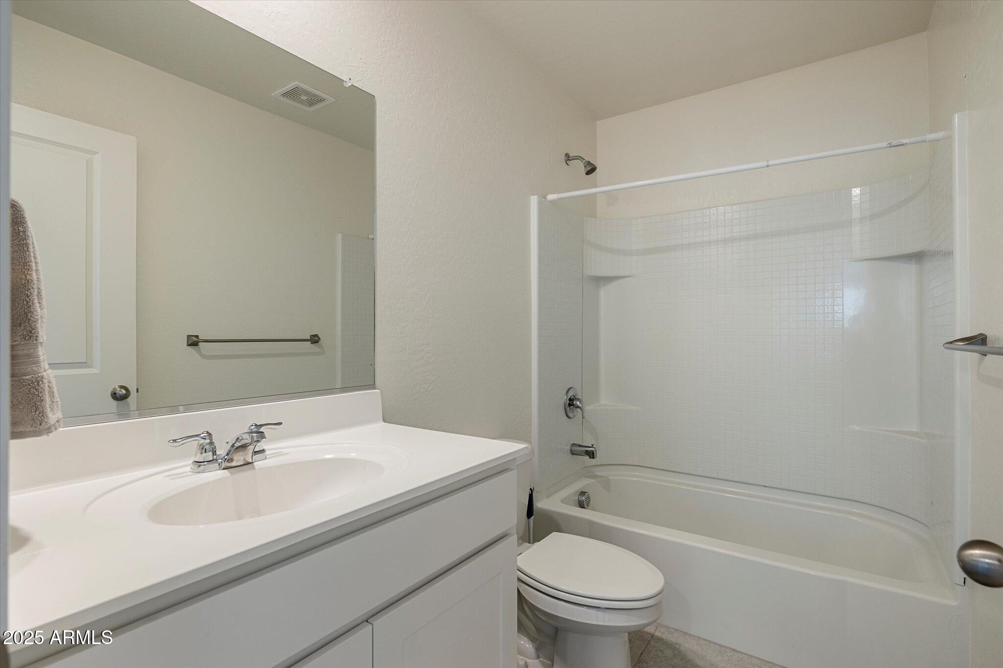 6350 West Latona Road Laveen, AZ 85339 - Photo 30 of 42 a bathroom with a bathtub shower sink vanity mirror and toilet