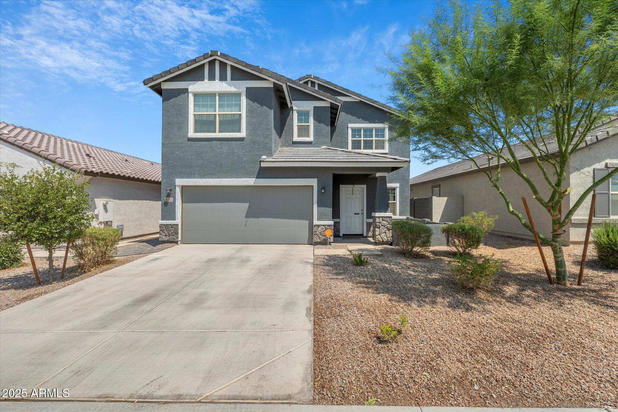 6350 West Latona Road Laveen, AZ 85339 - Photo 4 of 42 a front view of a house with a yard and garage