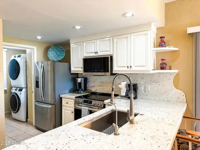 a kitchen with a refrigerator a stove top oven a sink dishwasher and wooden cabinets with wooden floor