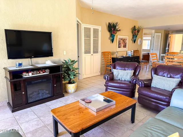a bedroom with a bed next to a window with a flat screen tv