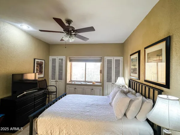 a bedroom with a large bed and a chandelier