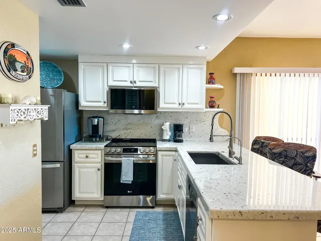 a kitchen with a stove a sink and a microwave