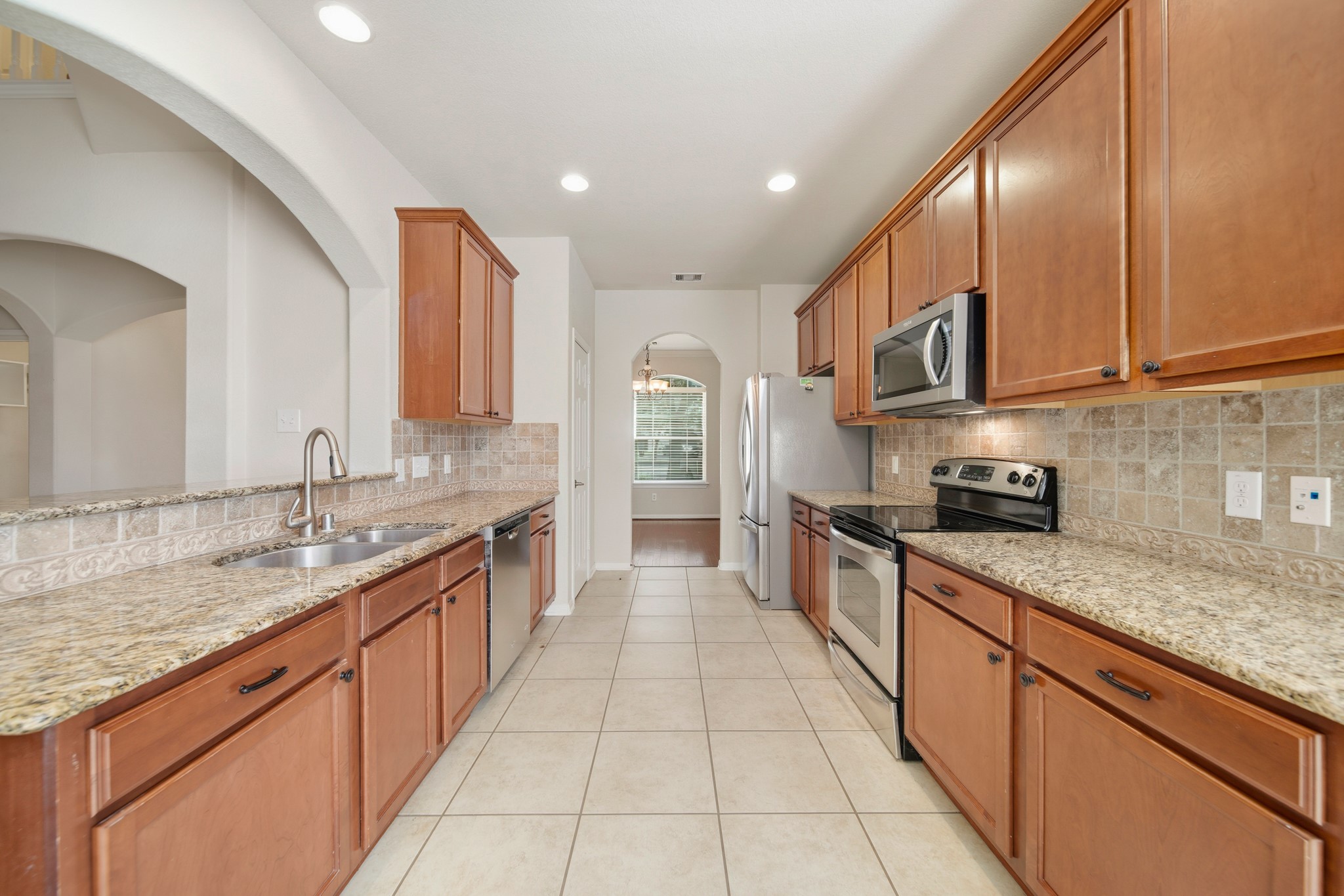 6015 Biltmore Court Rosenberg, TX 77471 - Photo 8 of 31 a large kitchen with stainless steel appliances granite countertop a sink and cabinets