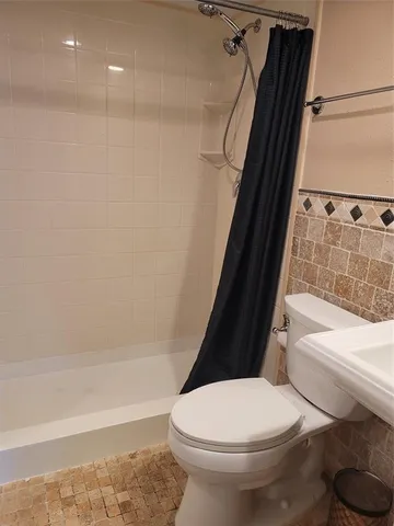 a bathroom with a sink toilet and shower