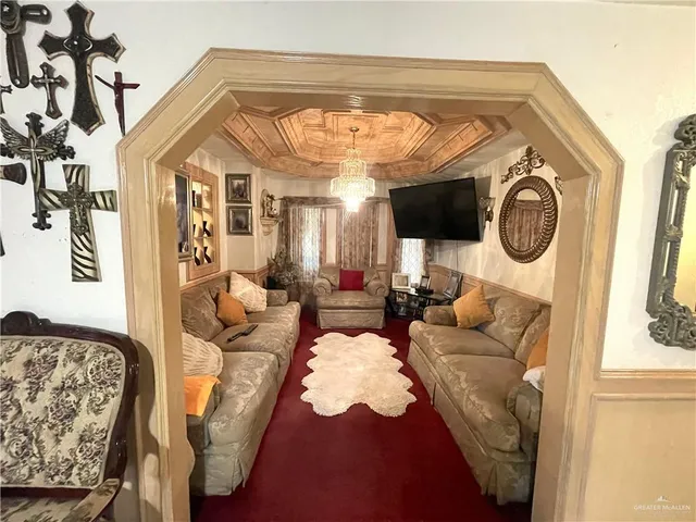 a view of a white house with a small yard and a large tree