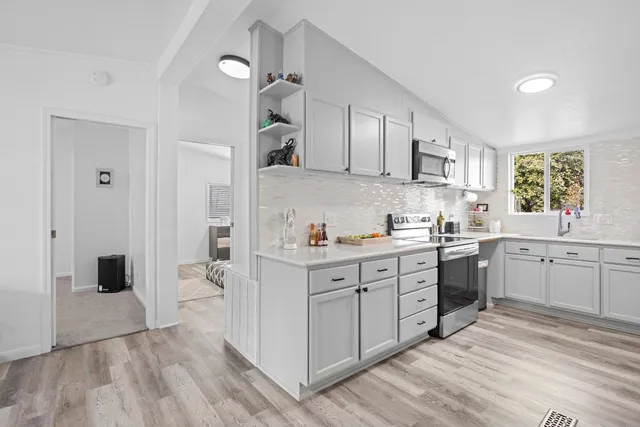 a kitchen with a sink cabinets and wooden floor
