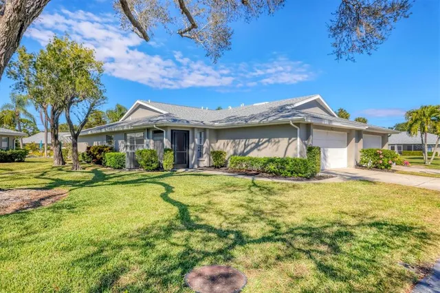 a view of a house with a big yard and large trees