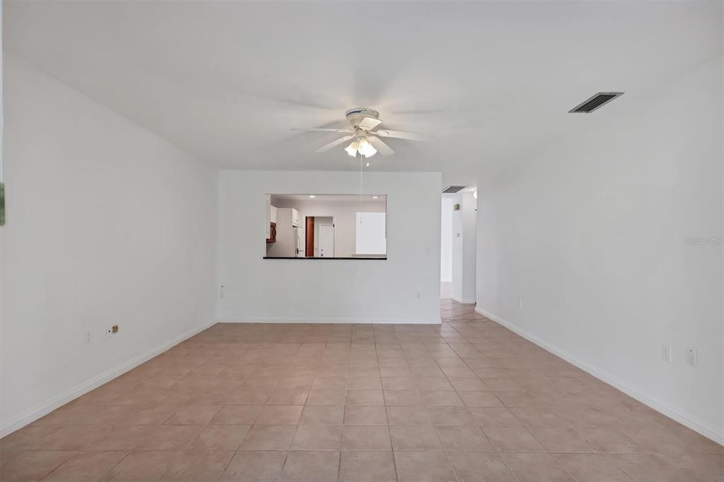 3930 Center Gate Circle, Unit 16 Sarasota, FL 34233 - Photo 15 of 30 an empty room with a chandelier fan and windows