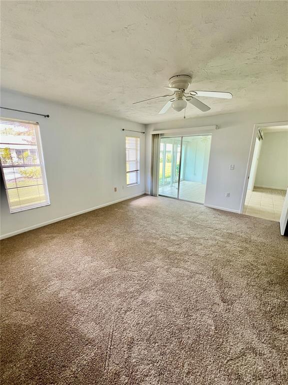 3930 Center Gate Circle, Unit 16 Sarasota, FL 34233 - Photo 19 of 30 an empty room with windows and ceiling fan