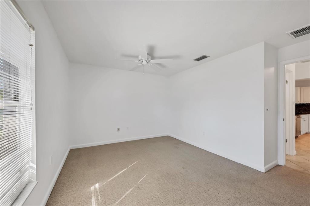 3930 Center Gate Circle, Unit 16 Sarasota, FL 34233 - Photo 22 of 30 an empty room with a ceiling fan and a window