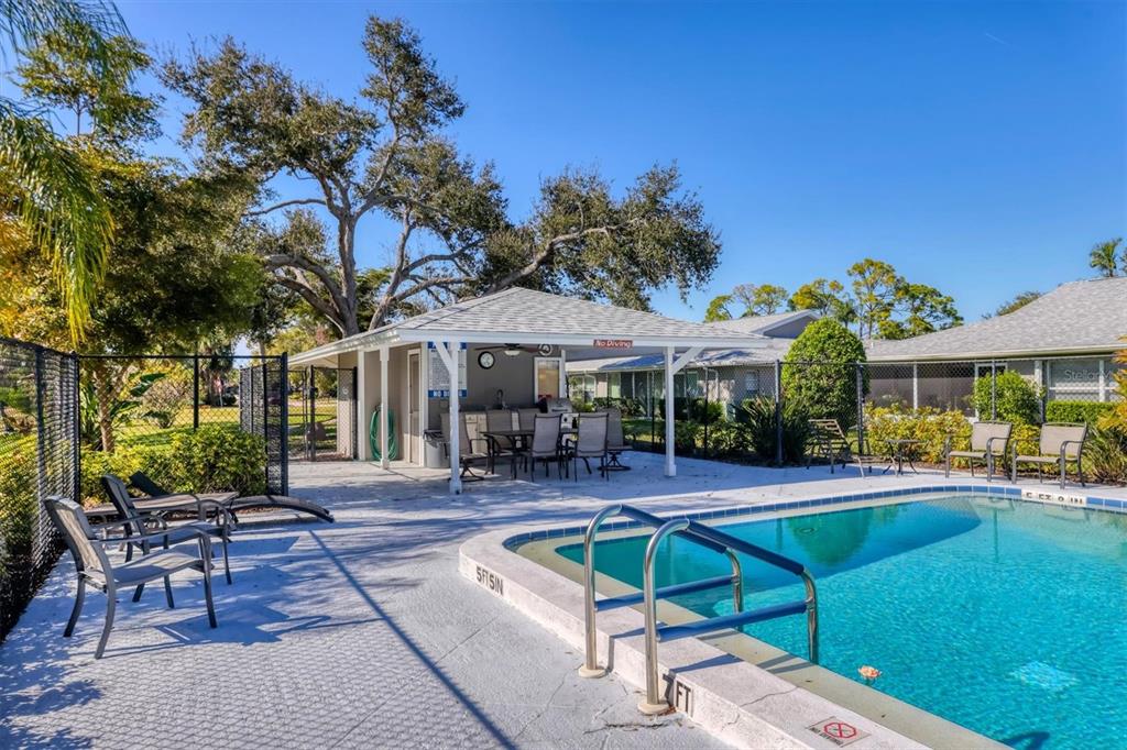 3930 Center Gate Circle, Unit 16 Sarasota, FL 34233 - Photo 30 of 30 a patio with a table and chairs under an umbrella