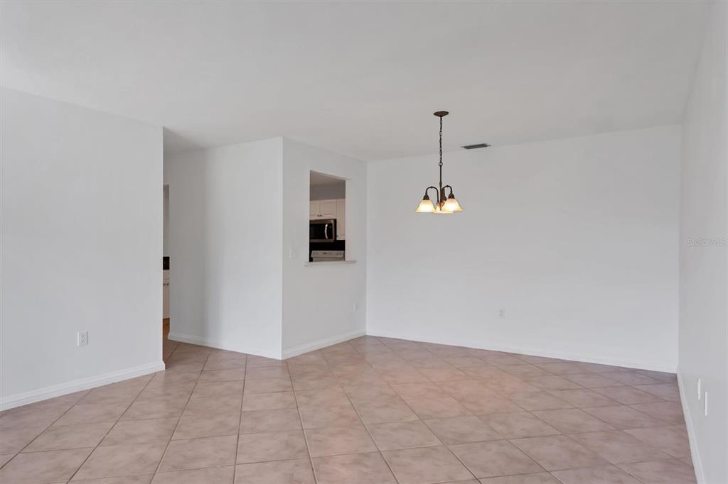 3930 Center Gate Circle, Unit 16 Sarasota, FL 34233 - Photo 7 of 30 a view of a room with a flat screen tv and a ceiling fan