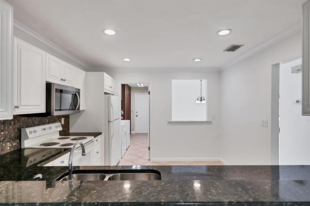 3930 Center Gate Circle, Unit 16 Sarasota, FL 34233 - Photo 9 of 30 a kitchen with stainless steel appliances granite countertop a refrigerator and a stove top oven