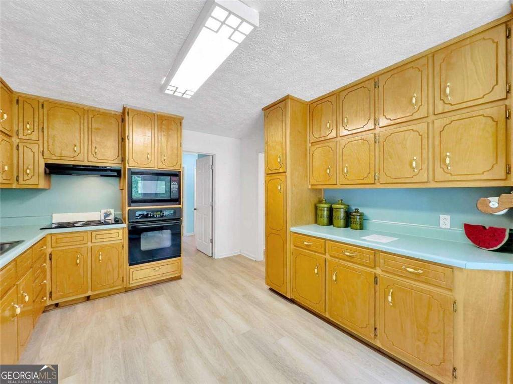 240 Riverview Road Jackson, GA 30233 - Photo 35 of 79 a kitchen with stainless steel appliances granite countertop a sink a stove cabinets and wooden floor