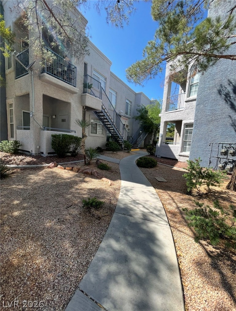 2201 Ramsgate Drive, Unit 915 Henderson, NV 89074 - Photo 6 of 36 A graceful curved walkway meanders through drought-tolerant landscaping toward multi-level residential structures.