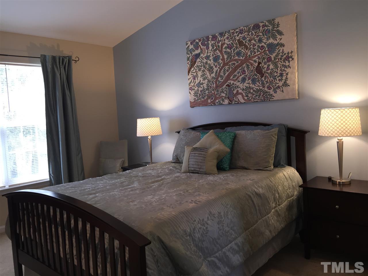 2136 Persimmon Ridge Drive Raleigh, NC 27604 - Photo 13 of 23 a bedroom with a bed and a lamp on dresser