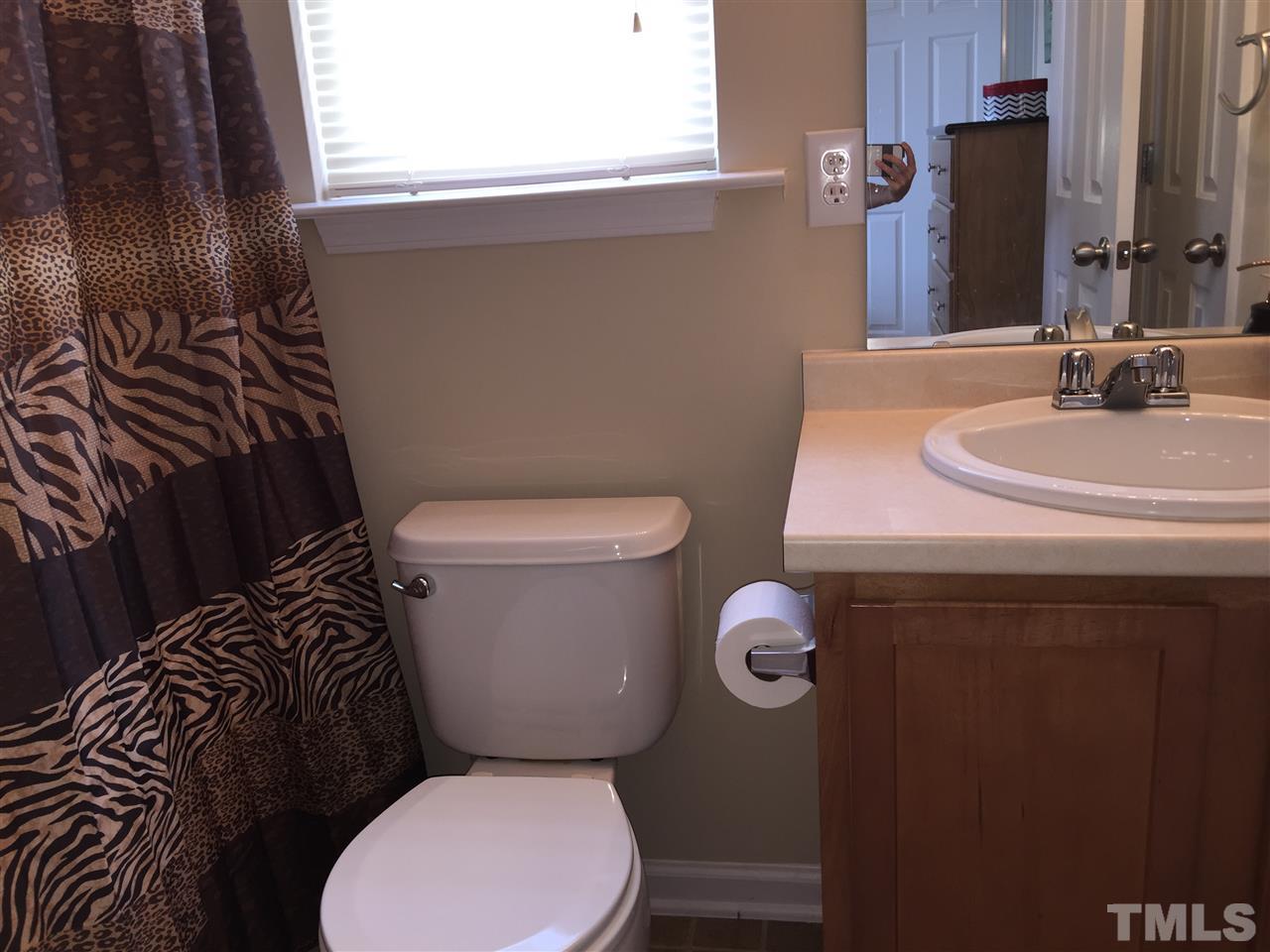 2136 Persimmon Ridge Drive Raleigh, NC 27604 - Photo 19 of 23 a white toilet sitting next to a bathroom sink