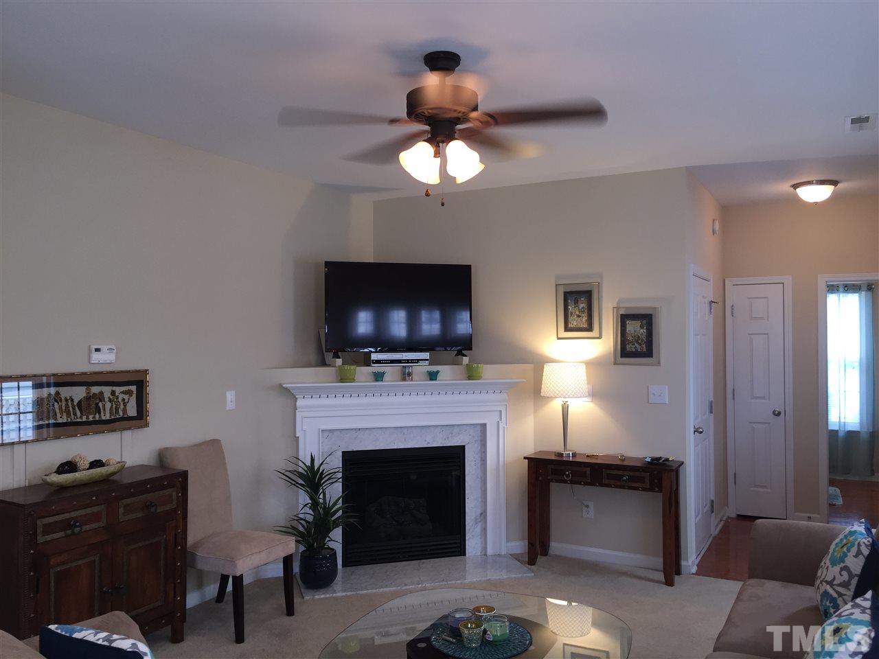 2136 Persimmon Ridge Drive Raleigh, NC 27604 - Photo 7 of 23 a living room with furniture a fireplace and a flat screen tv