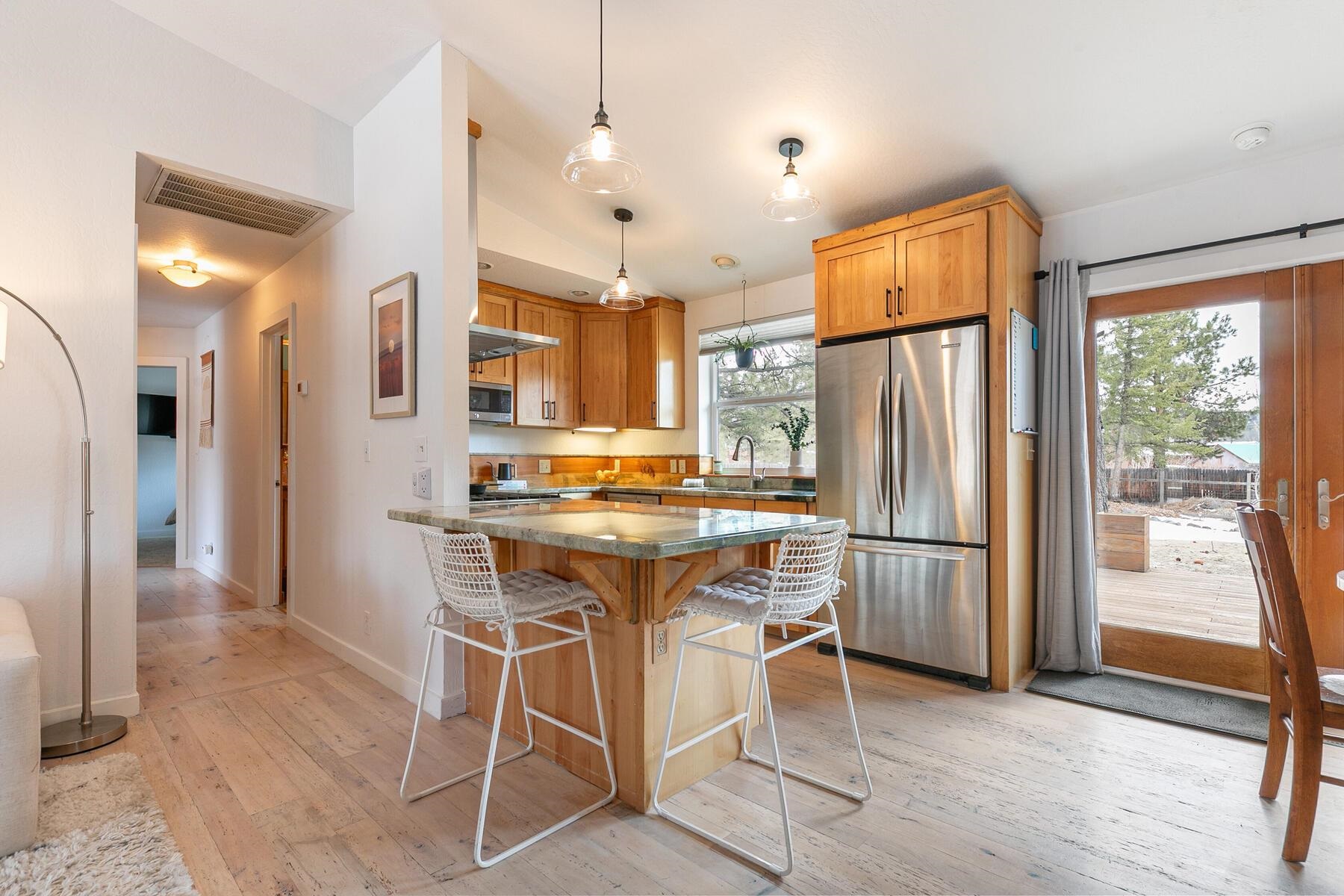 11151 Dorchester Drive Truckee, CA 96161 - Photo 6 of 27 a kitchen with stainless steel appliances granite countertop a refrigerator a stove a sink and a dining table with wooden floor