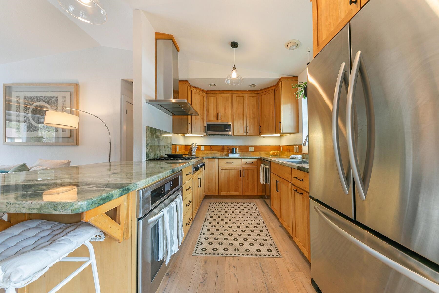 11151 Dorchester Drive Truckee, CA 96161 - Photo 7 of 27 a kitchen with stainless steel appliances granite countertop a refrigerator a sink dishwasher a stove and white countertops with wooden floor