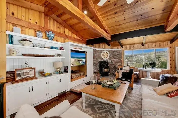3505 Deer Lake Park Road Julian, CA 92036 - Photo 20 of 46 a living room with furniture a fireplace and a large window
