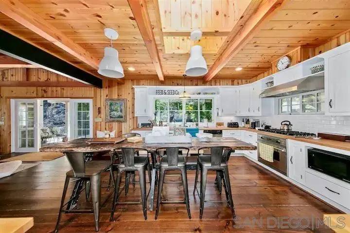 3505 Deer Lake Park Road Julian, CA 92036 - Photo 23 of 46 a kitchen with stainless steel appliances granite countertop a table chairs and wooden cabinets