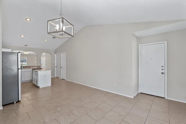 a view of an empty room and chandelier