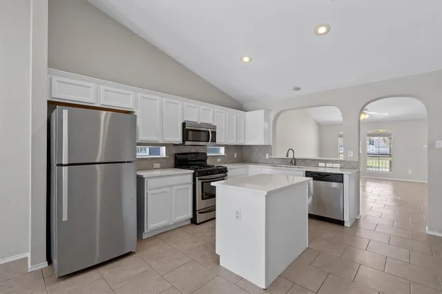 a kitchen with a refrigerator sink and stove
