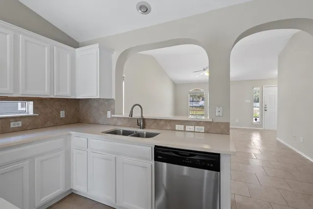 a kitchen with a sink dishwasher and cabinets