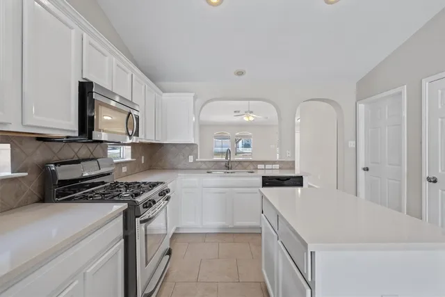 a kitchen with a sink stove and cabinets