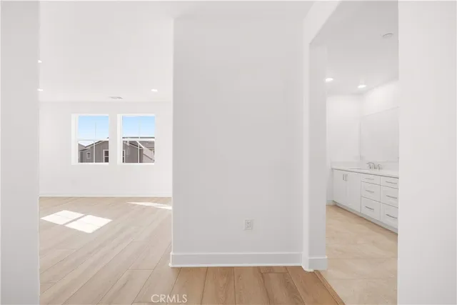 a view of an empty room with wooden floor and entryway