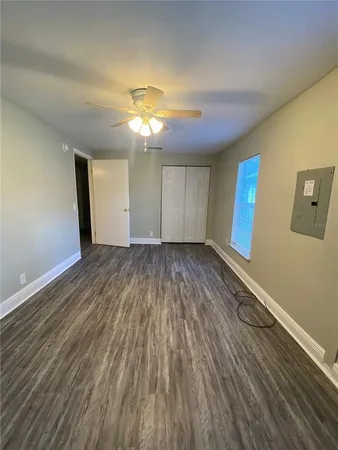 a view of empty room with wooden floor and fan