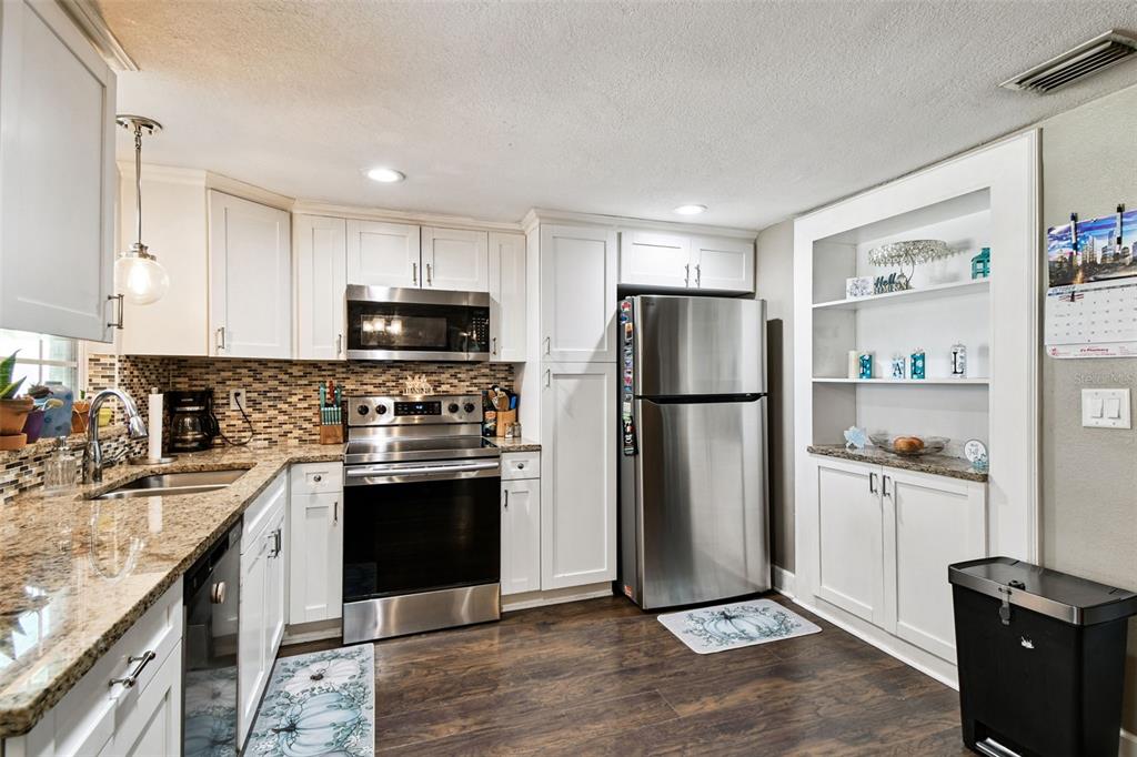 5831 1st Avenue New Port Richey, FL 34652 - Photo 7 of 22 a kitchen with stainless steel appliances granite countertop a refrigerator stove and sink