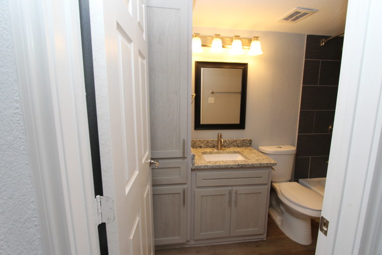 6509 Berkman Drive, Unit 114 Austin, TX 78723 - Photo 8 of 16 a bathroom with a granite countertop toilet sink and mirror