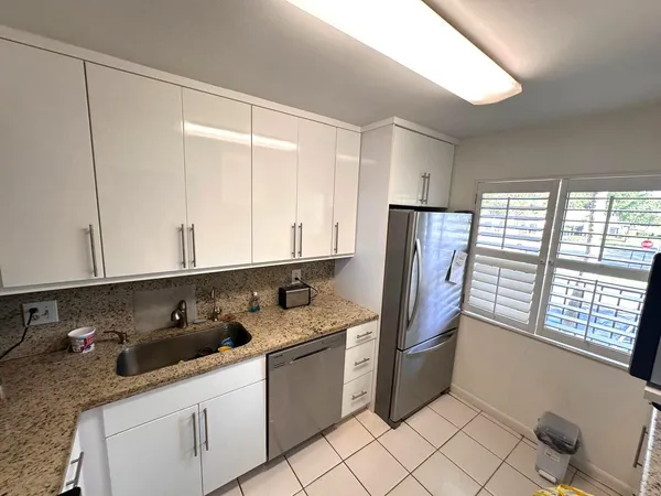 a kitchen with stainless steel appliances granite countertop a refrigerator and sink