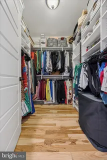 a view of walk in closet with clothes and shoes