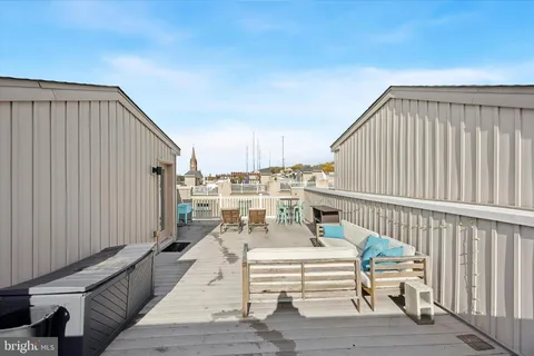 a view of a balcony with wooden floor and seating space