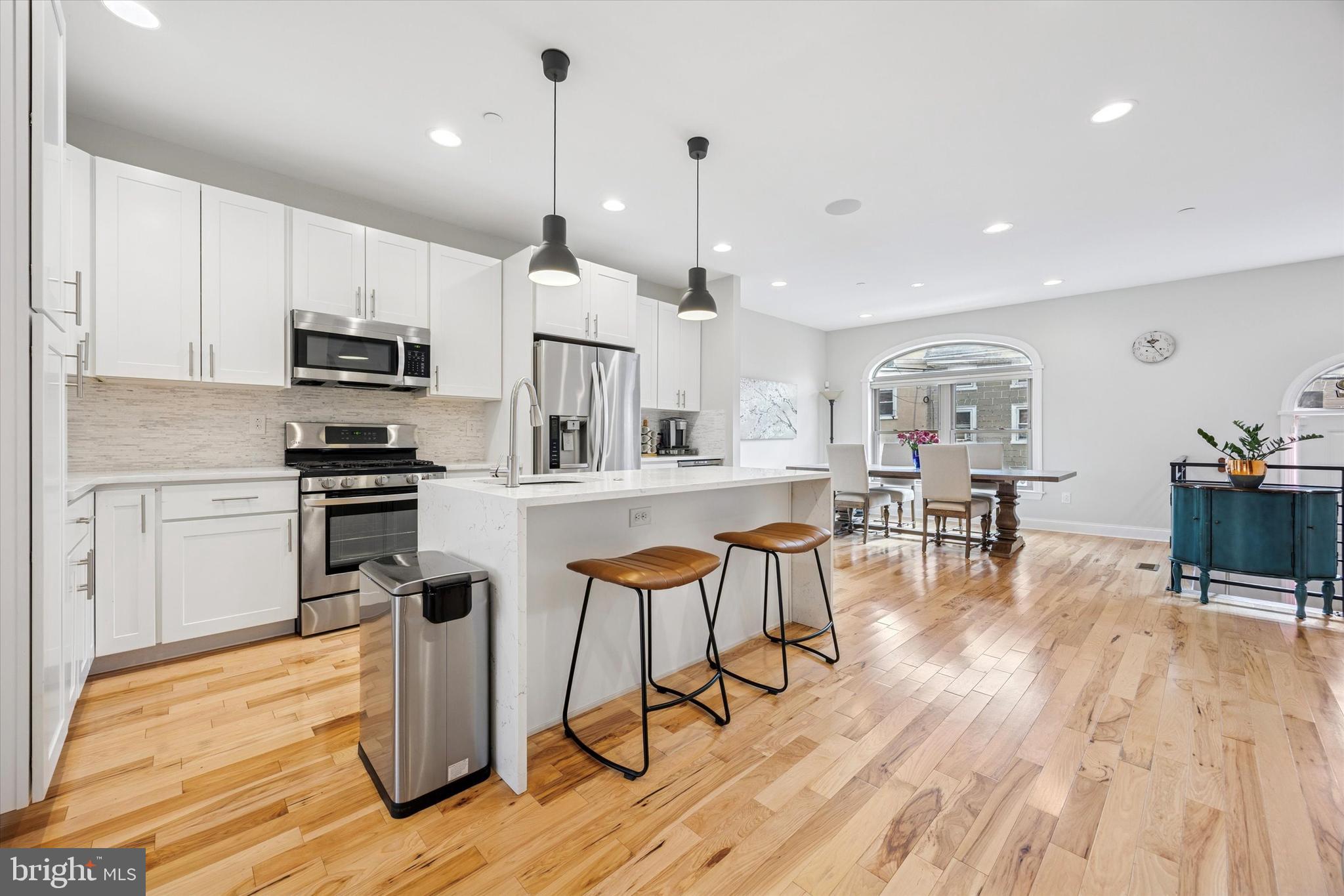 152 Carson Street Philadelphia, PA 19127 - Photo 3 of 33 a kitchen with stainless steel appliances kitchen island granite countertop a table chairs refrigerator and sink